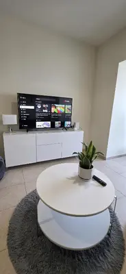 a living room with a white table and a tv at Elite Residence, Marina in Dubai