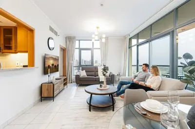 a man and woman sitting in a living room at Modern Retreat in The Views with Balcony & Pool in Dubai