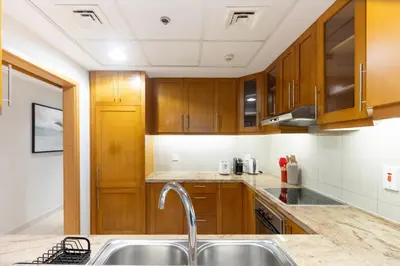 a kitchen with wooden cabinets and a sink at Modern Retreat in The Views with Balcony & Pool in Dubai