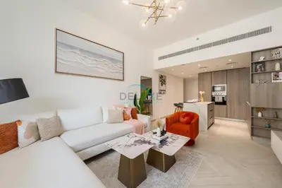 a living room with a white couch and a table at Few Minutes Walk to Circle Mall, Conveniently Close Community Park, and Near the Bus Station for Effortless Metro Access - Oxford Terraces, JVC by Deluxe Holiday Homes in Dubai