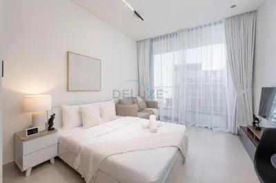 a white bedroom with a bed and a couch at High-Floor Studio Overlooking the Community, Just a Short Drive to Miracle Garden, Binghatti Azure, JVC by Deluxe Holiday Homes in Dubai
