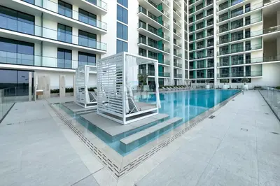 a swimming pool in the middle of a building at High-Floor Studio Overlooking the Community, Just a Short Drive to Miracle Garden, Binghatti Azure, JVC by Deluxe Holiday Homes in Dubai