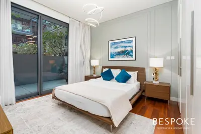 a bedroom with a large bed with blue pillows at Bespoke Holiday Homes - 2BR plus Kids room in City Walk with Direct Pool Access in Dubai