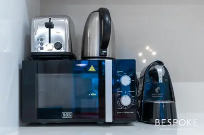 a kitchen with a microwave and a toaster and a coffee maker at Bespoke Holiday Homes - 2BR plus Kids room in City Walk with Direct Pool Access in Dubai