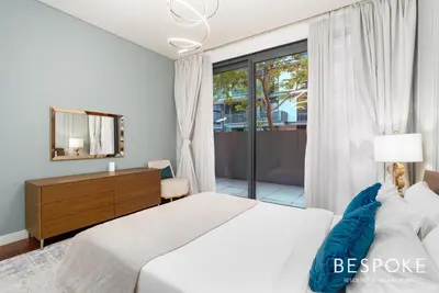 a bedroom with a bed and a dresser and a window at Bespoke Holiday Homes - 2BR plus Kids room in City Walk with Direct Pool Access in Dubai