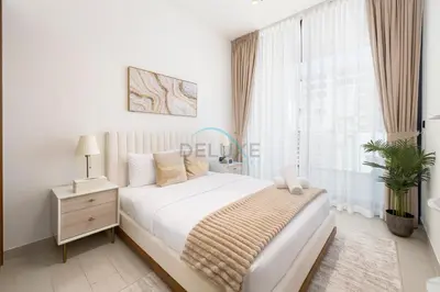 a white bedroom with a bed and a window at Close to Community Park, Minutes Walk from Circle Mall, and Short Drive to Dubai Miracle Garden and Butterfly Garden - Binghatti Amber, JVC by Deluxe Holiday Homes in Dubai