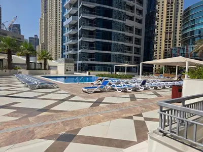 a swimming pool with lounge chairs in a city at Spacious 1BHK Apt with Canal View in Dubai Marina in Dubai