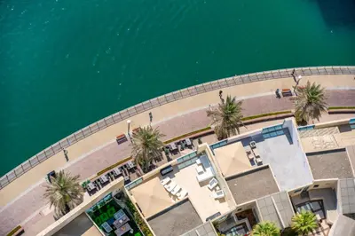 an overhead view of a beach with palm trees and a body of water at Spacious 1BHK Apt with Canal View in Dubai Marina in Dubai