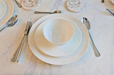 a white plate sitting on top of a table with silverware at Golden Stays - Luxe 4BR Villa Family-Friendly and Fully Equipped in Dubai