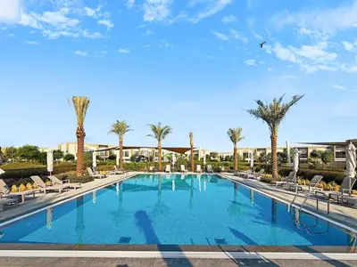 a large swimming pool with chairs and palm trees at Golden Stays - Luxe 4BR Villa Family-Friendly and Fully Equipped in Dubai