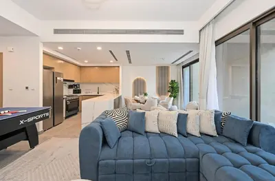 a living room with a blue couch and a kitchen at Golden Stays - Luxe 4BR Villa Family-Friendly and Fully Equipped in Dubai