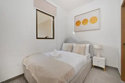 a white bedroom with a bed and a mirror at Golden Stays - Luxe 4BR Villa Family-Friendly and Fully Equipped in Dubai