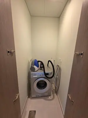 a bathroom with a washing machine in a room at Act Tower 410 in Dubai