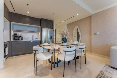 a kitchen and dining room with a table and chairs at Direct Private Beach Access, Proximity To Key Dubai Attractions Like Dubai Marina, Palm Jumeirah, And JBR Walk - Palace Beach Residence Tower 2, Emmar Beachfront by Deluxe Holiday Homes in Dubai