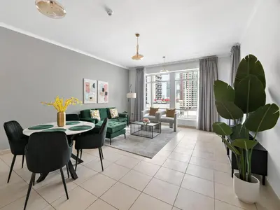 a living room with a green couch and a table at Serene 1BDR Unit -Burj Views, Downtown in Dubai