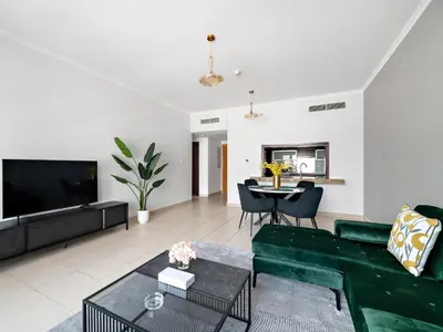 a living room with a green couch and a table at Serene 1BDR Unit -Burj Views, Downtown in Dubai