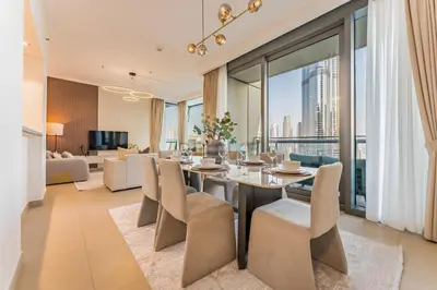 a dining room with a table and chairs and a living room at High Floor with Direct Burj Khalifa and Fountain Views, Just Steps from Dubai Mall and Metro Station - Burj Vista Tower 1, Downtown Dubai by Deluxe Holiday Homes in Dubai