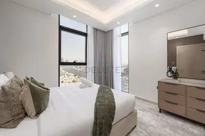 a bedroom with a large bed and a television at Modern 1BR Haven Near the Park, Offering Effortless Connectivity to Key Roads, Cloud A, Jumeirah Village Triangle by Deluxe Holiday Homes in Dubai
