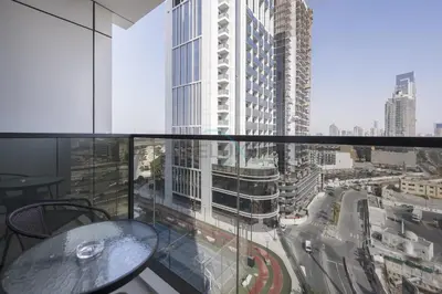 a balcony with a table and a view of a city at Modern 1BR Haven Near the Park, Offering Effortless Connectivity to Key Roads, Cloud A, Jumeirah Village Triangle by Deluxe Holiday Homes in Dubai