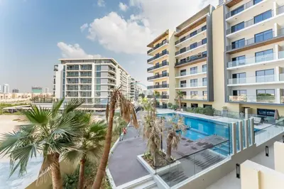 an apartment with a swimming pool and palm trees at Walking Distance to Miracle Garden and Butterfly Garden, 20 Minutes Drive to Dubai Marina and Palm Jumeirah - Divine Living, Arjan, by Deluxe Holiday Homes in Dubai