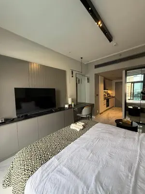 a bedroom with a large white bed with a flat screen tv at Furnished Studio 2 min Walk to Burji Khalifa in Dubai