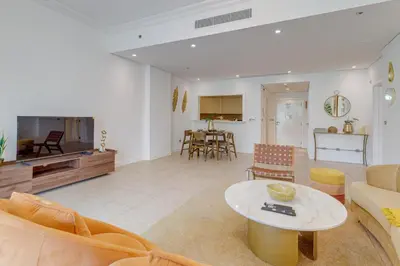 a living room with a couch and a table at Al Sarrood, Palm Jumeirah - 1 Bedroom Apartment - Allsopp & Allsopp in Dubai