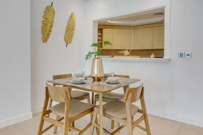 a dining room table with chairs and a vase on it at Al Sarrood, Palm Jumeirah - 1 Bedroom Apartment - Allsopp & Allsopp in Dubai