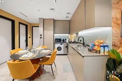 a kitchen with a table and yellow chairs in a kitchen at Luxury High Floor 1BHK Burj and Canal Views in Dubai