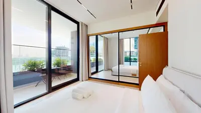 a bedroom with white furniture and large windows at Vacationer l 1 Bedroom in Business Bay l Direct Pool Access in Dubai