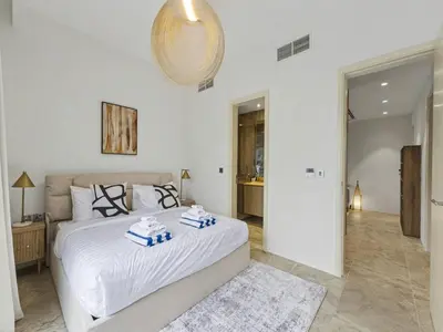 a bedroom with a bed with two towels on it at Redwood Townhouse Jumeirah Golf Estates in Dubai