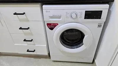 a white washing machine sitting next to some drawers at Beach, Palm Jumeirah & Marina view in Dubai