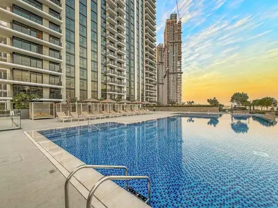 a large swimming pool in a city with tall buildings at FIRST CLASS 1BR Creek Escape & Modern Elegance in Dubai