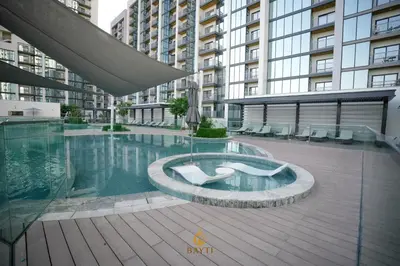 a swimming pool in a building with a large building at Evasion de luxe avec vue piscine, billard et lounge, à 15 minutes burj khalifa in Dubai