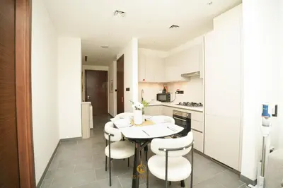 a kitchen with a table and chairs in a room at Evasion de luxe avec vue piscine, billard et lounge, à 15 minutes burj khalifa in Dubai