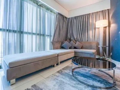 a living room with a couch and a glass table at Paramount Tower - Stylish 2BR Apartment with Balcony & Pool - Near Dubai Mall in Dubai