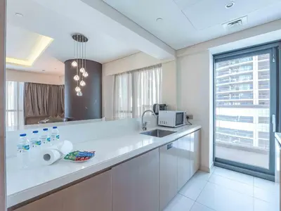 a kitchen with a sink and a microwave at Paramount Tower - Stylish 2BR Apartment with Balcony & Pool - Near Dubai Mall in Dubai