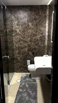 a bathroom with a toilet and a sink and a shower at Futuristic luxury apartment, 360 lake view balcony in Dubai