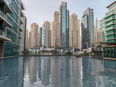 a city skyline with tall buildings and a swimming pool at 1 Bedroom in Dubai Marina Walk, Partial Water View in Dubai