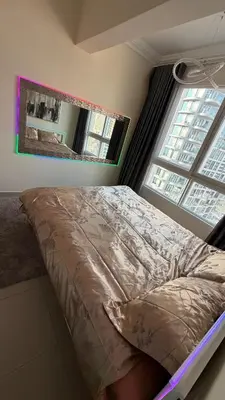a bed in a bedroom with a large window at Luxury 1BR Apt with water canal & Marina View in Dubai