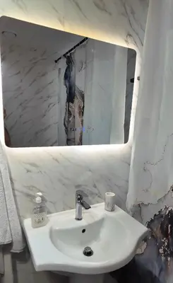 a white sink in a bathroom with a mirror at Luxury 1BR Apt with water canal & Marina View in Dubai