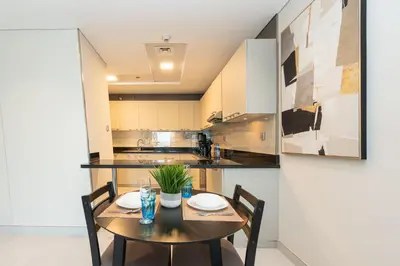 a dining room with a table and chairs in a kitchen at PVH - Refined 1BR in Marina - Cayan Tower in Dubai