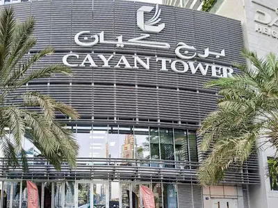 a building with a sign on the front of it at PVH - Refined 1BR in Marina - Cayan Tower in Dubai