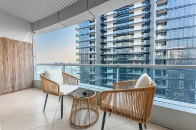 a balcony with chairs and a table and a large window at StayShort - 1 Bed Apartment Sleeps 4 in Dubai Marina in Dubai