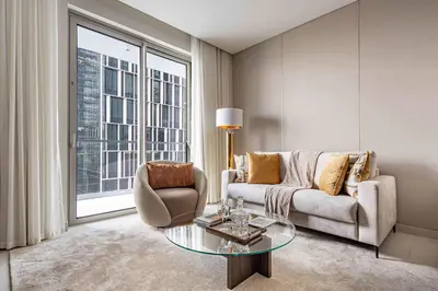 a living room with a couch and a glass table at Frank Porter - Vida Residences Dubai Mall in Dubai