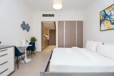 a bedroom with a white bed and a table and chairs at Modern Marina Studio w City Views & King Bed in Dubai