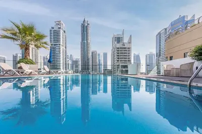 a swimming pool in the middle of a city with tall buildings at Modern Marina Studio w City Views & King Bed in Dubai