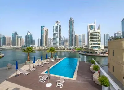 a swimming pool with chairs and a city skyline at Modern Marina Studio w City Views & King Bed in Dubai