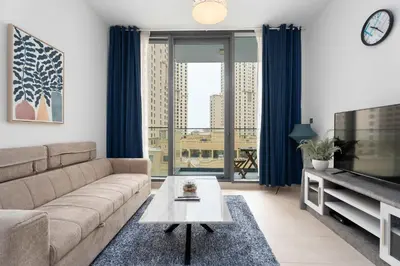 a living room with a couch and a tv at Modern Marina Studio w City Views & King Bed in Dubai