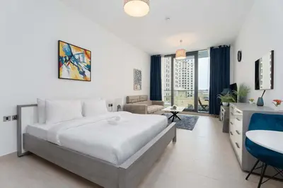 a bedroom with a large bed and a living room at Modern Marina Studio w City Views & King Bed in Dubai