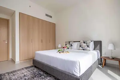 a bedroom with a large bed and a wooden cabinet at Frank Porter - Island Park 2 in Dubai